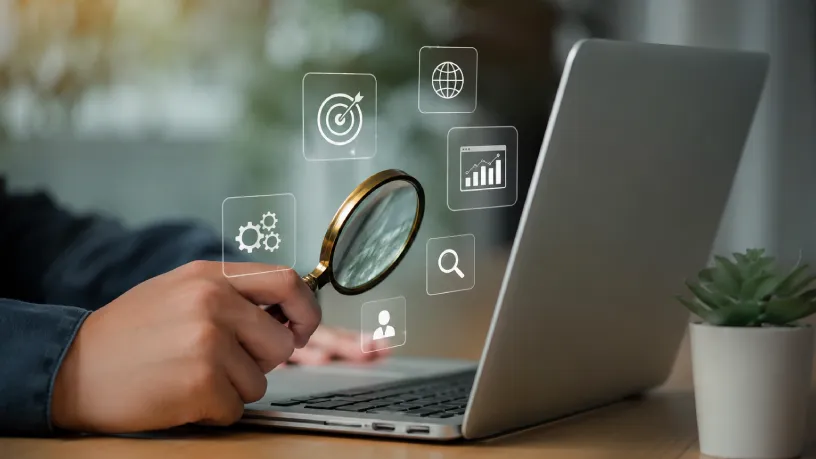 Como criar uma estratégia eficiente de monitoramento representada por profissional analisando dados em notebook com lupa e ícones digitais, destacando pesquisa, métricas, desempenho e acompanhamento estratégico da presença online.