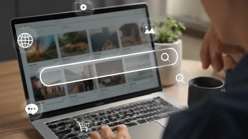 Pessoa utilizando um notebook para realizar pesquisas online, com barra de busca e ícones digitais representando conteúdo, navegação e resultados de pesquisa. Cena moderna relacionada à presença digital, mecanismos de busca e visibilidade na internet.